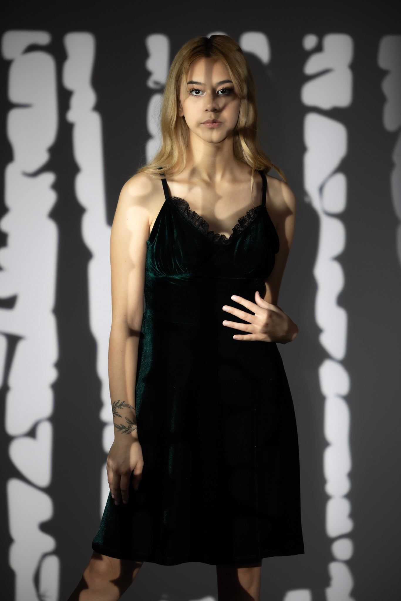 Olivia Noire Fashion gothic velvet slip dress worn by model with shadow patterns on gray background