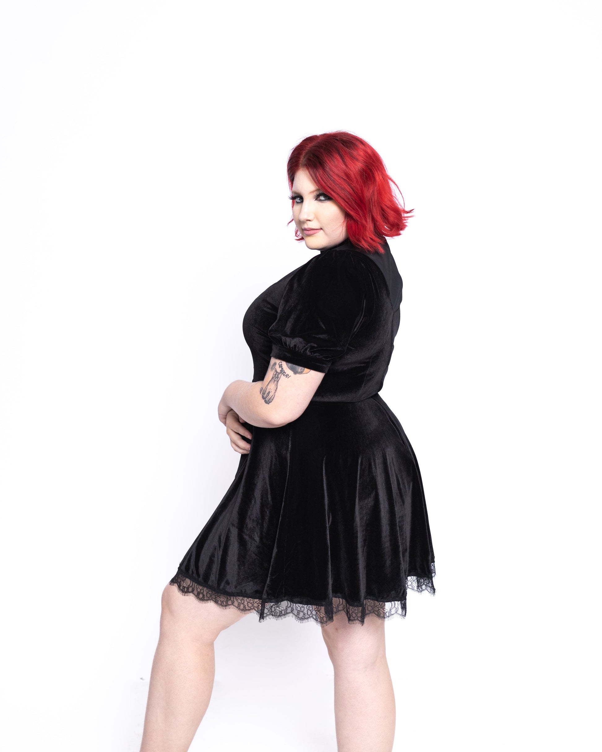 Woman wearing a short sleeve gothic dress for women in black velvet with lace trim